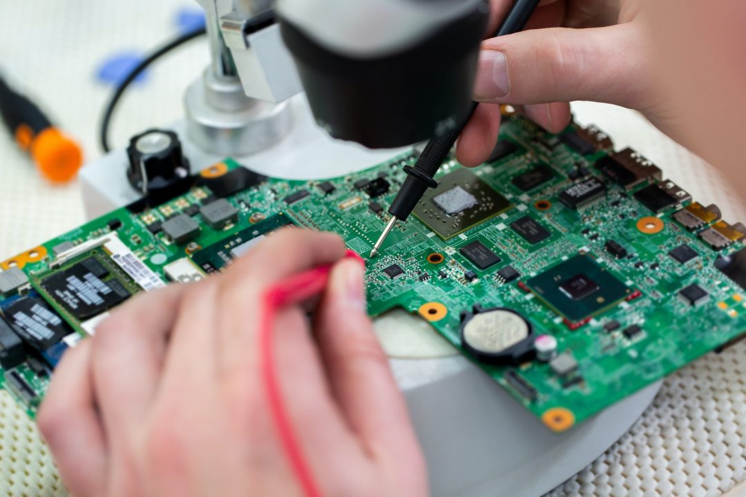the-master-checks-a-broken-laptop-with-a-multimeter